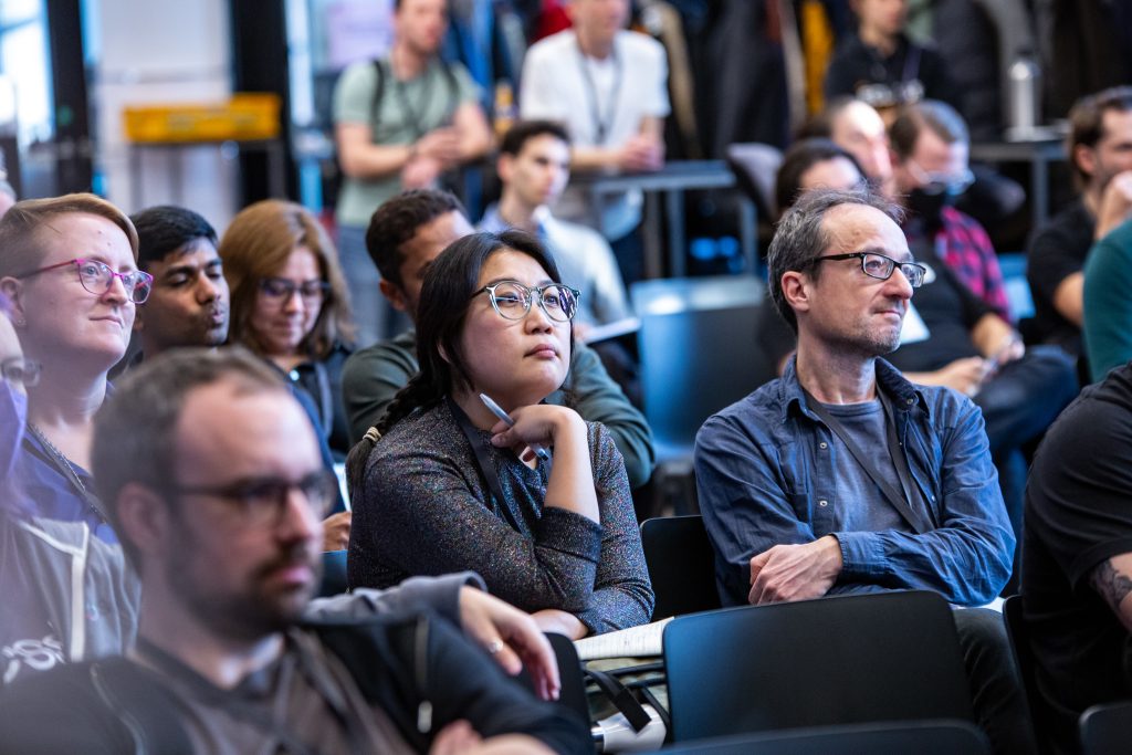 The audience on the main stage listening to a talk with concentrated faces.