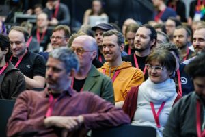 smiling audience members in a packed main room